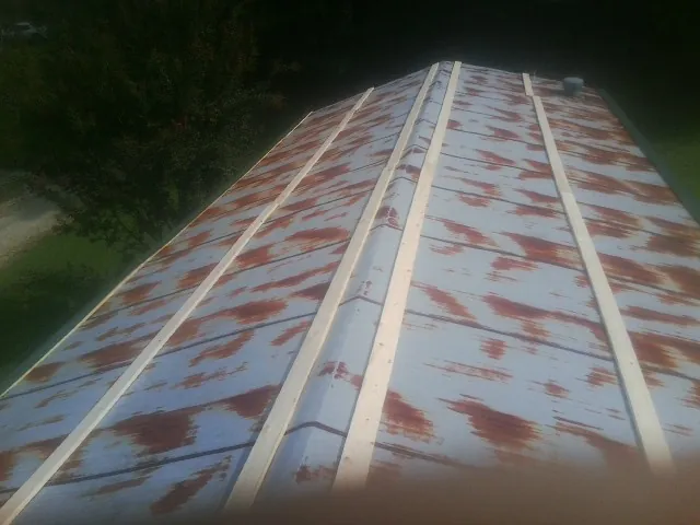 Rusted metal roof panels with new wood purlins before replacement — Storm Damage Roof Repair in O Fallon by Roofing Brothers